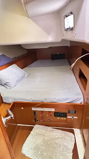  Yacht Photos Pics Cozy cabin interior of 2010 Beneteau Oceanis 50 sailboat with bed and control panel.