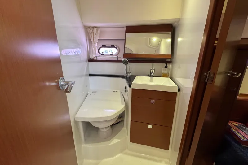  Yacht Photos Pics Compact bathroom in 2014 Prestige 400 yacht with modern fixtures and wooden cabinetry.