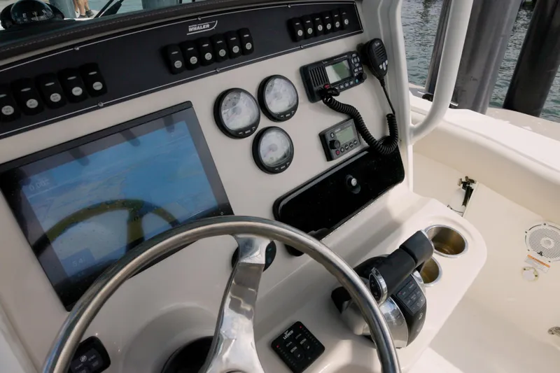 250 Outrage Yacht Photos Pics 2022 Boston Whaler 250 Outrage boat dashboard with steering wheel and navigation controls.