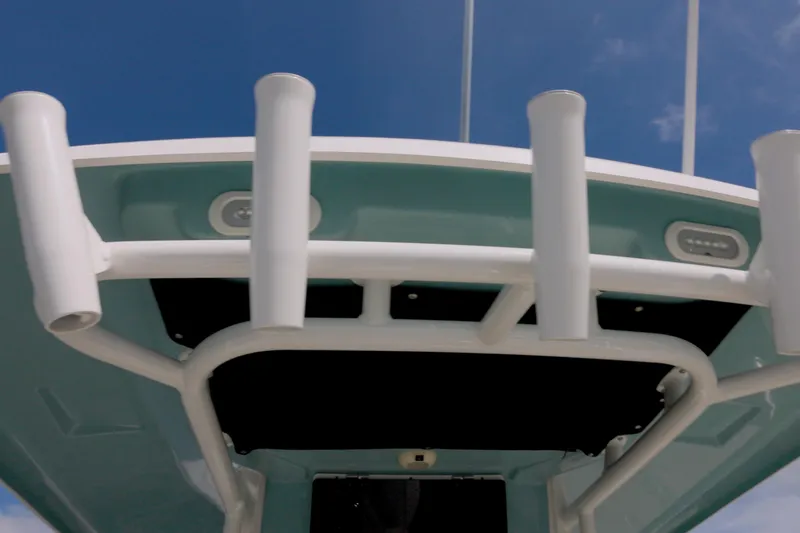 250 Outrage Yacht Photos Pics 2022 Boston Whaler 250 Outrage boat, featuring rod holders and sleek design against blue sky.