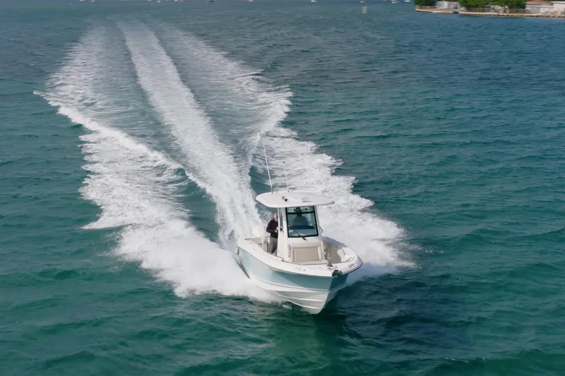 250 Outrage Yacht Photos Pics 2022 Boston Whaler 250 Outrage cruising on open water, leaving a wake trail.