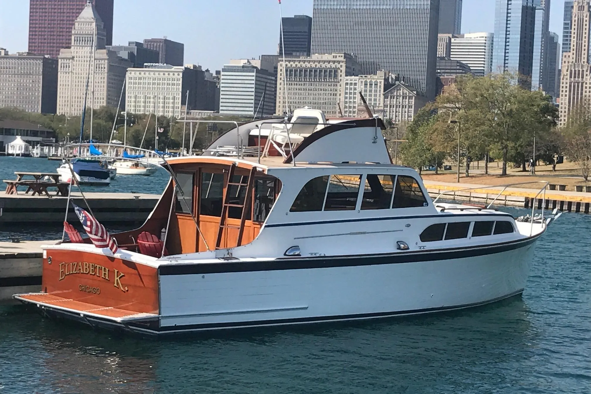 1964 Pacemaker 36 Sportfisherman boat docked in urban marina with city skyline.