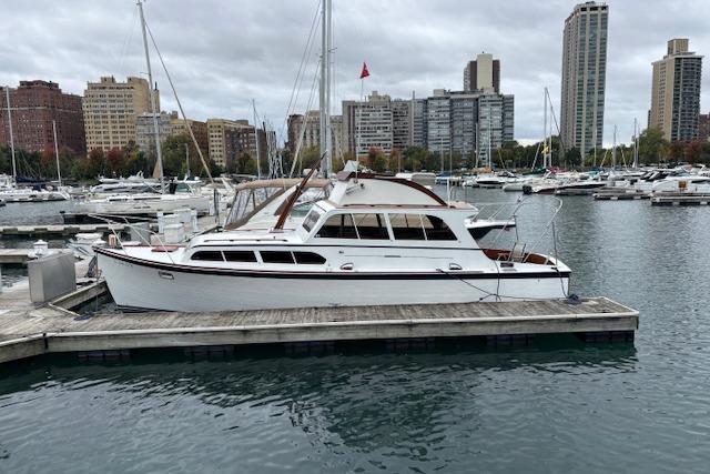 1964 Pacemaker 36 Sportfisherman docked in urban marina with city skyline.