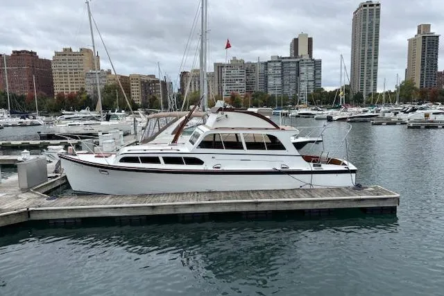 1964 Pacemaker 36 Sportfisherman docked in urban marina with city skyline.