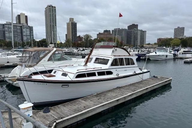 1964 Pacemaker 36 Sportfisherman docked in a marina with city skyline backdrop.