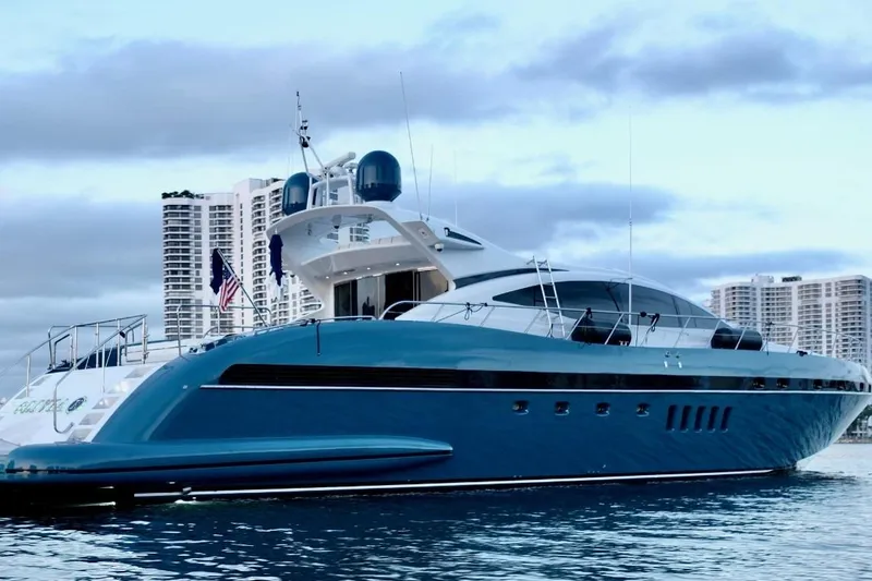 Olivia K Yacht Photos Pics Luxurious 2005 Mangusta 92 yacht docked with city skyline backdrop.