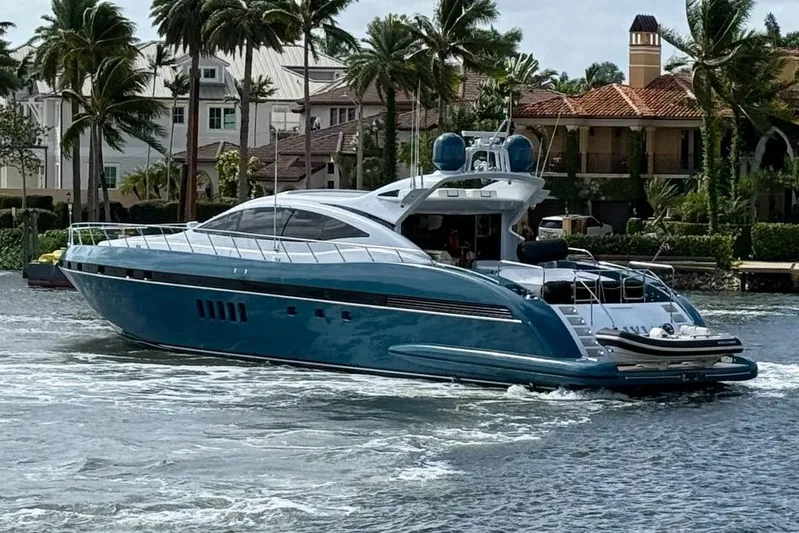 Olivia K Yacht Photos Pics Luxury 2005 Mangusta 92 yacht cruising near palm-lined waterfront homes.