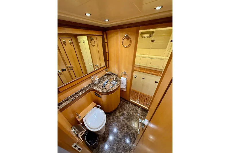 Olivia K Yacht Photos Pics Luxurious bathroom in 2005 Mangusta 92 yacht with marble accents and modern fixtures.