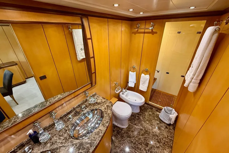 Olivia K Yacht Photos Pics Luxurious bathroom in 2005 Mangusta 92 yacht with marble countertop and wooden paneling.