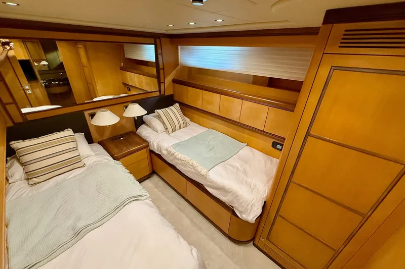 Olivia K Yacht Photos Pics Luxurious twin cabin interior of 2005 Mangusta 92 yacht with wooden furnishings.