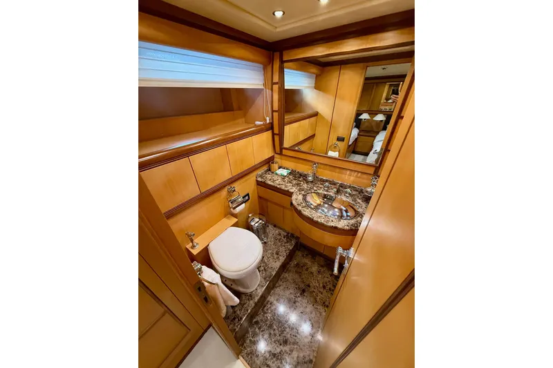 Olivia K Yacht Photos Pics Luxurious bathroom in a 2005 Mangusta 92 yacht with marble countertop and wooden cabinetry.