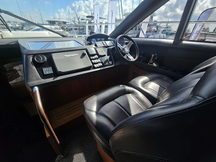 Yacht Photos Pics Luxurious 2013 Princess 52 Flybridge yacht helm with leather seating and modern controls.