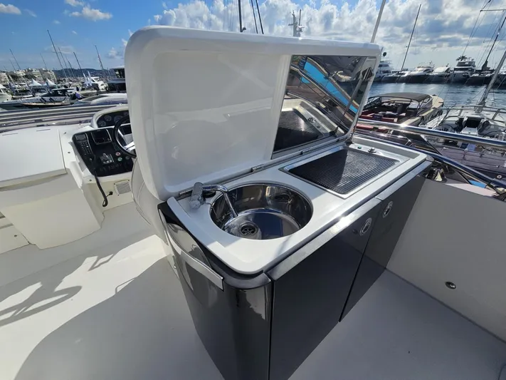  Yacht Photos Pics Outdoor kitchenette on 2013 Princess 52 Flybridge yacht, featuring sink and grill.