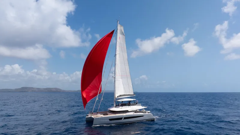  Yacht Photos Pics Fountaine Pajot Samana 59 catamaran sailing with red spinnaker on open sea, 2020 model.