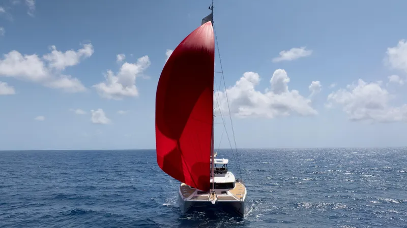  Yacht Photos Pics Fountaine Pajot Samana 59 sailing with a vibrant red sail on open ocean.