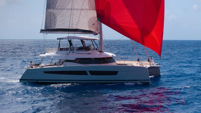  Yacht Photos Pics Fountaine Pajot Samana 59 catamaran sailing with red spinnaker on open sea, 2020 model.