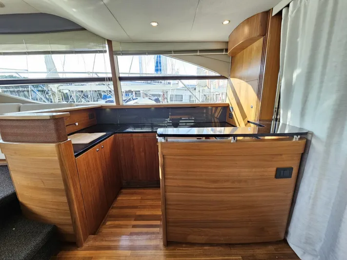  Yacht Photos Pics Luxurious interior of 2013 Princess 52 Flybridge yacht with wooden cabinetry and large windows.