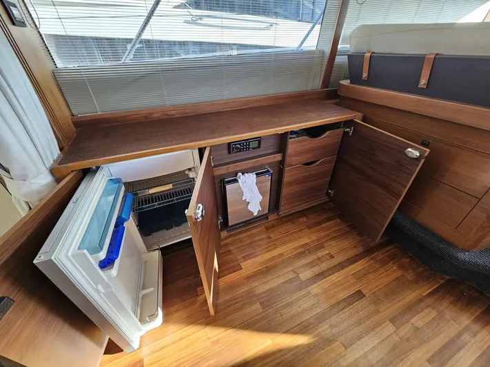  Yacht Photos Pics Interior of 2013 Princess 52 Flybridge yacht with open cabinets and mini fridge.