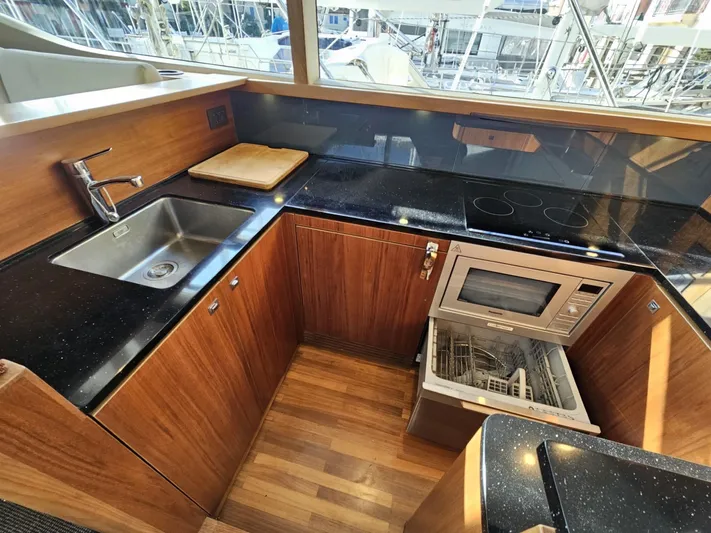  Yacht Photos Pics Luxurious 2013 Princess 52 Flybridge yacht kitchen with modern appliances and sleek wood finish.