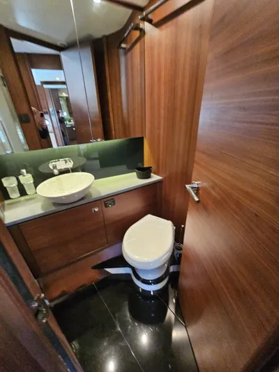  Yacht Photos Pics Luxurious bathroom in 2013 Princess 52 Flybridge yacht with modern fixtures and wood paneling.