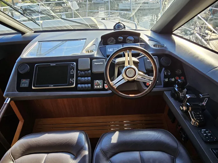  Yacht Photos Pics Helm of 2013 Princess 52 Flybridge yacht with modern navigation controls and leather seating.