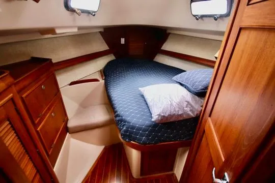 Solasta Yacht Photos Pics Cozy cabin interior of 1997 Island Packet 350 sailboat with wooden furnishings and bed.