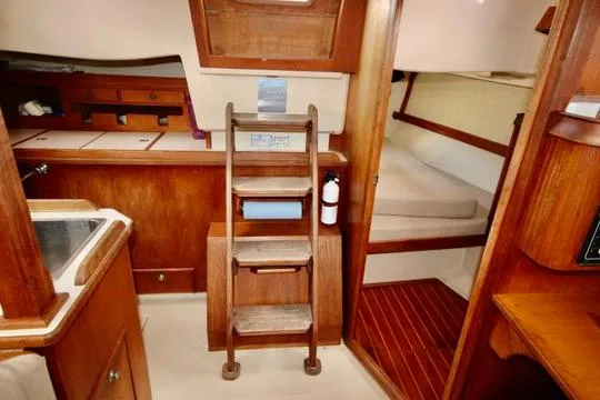 Solasta Yacht Photos Pics Interior of 1997 Island Packet 350 sailboat with wooden cabinetry and cozy sleeping area.