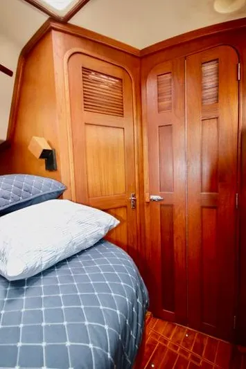 Solasta Yacht Photos Pics Cozy cabin interior of 1997 Island Packet 350 sailboat with wooden finish and bedding.