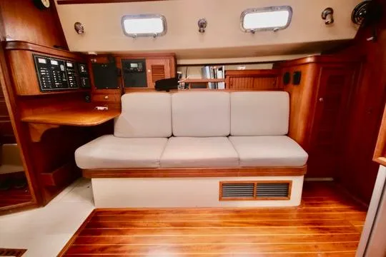 Solasta Yacht Photos Pics Interior of 1997 Island Packet 350 sailboat with wooden flooring and cushioned seating.