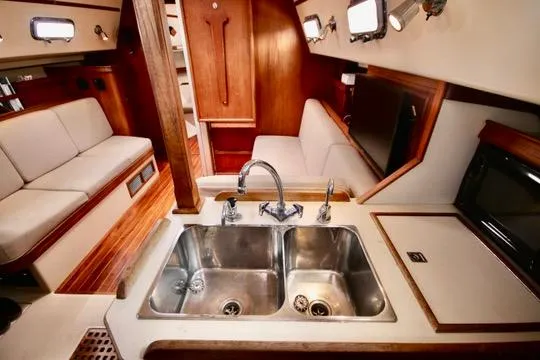 Solasta Yacht Photos Pics Interior of 1997 Island Packet 350 sailboat with dual sinks and cozy seating area.