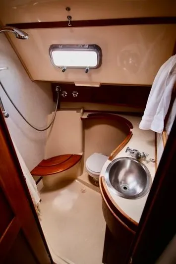 Solasta Yacht Photos Pics 1997 Island Packet 350 yacht bathroom with shower, sink, and wooden accents.