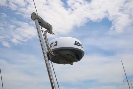 Solasta Yacht Photos Pics Radar equipment on a 1997 Island Packet 350 sailboat against a cloudy sky.