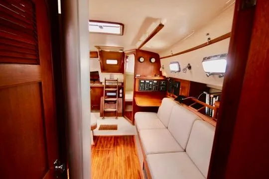 Solasta Yacht Photos Pics Interior of 1997 Island Packet 350 sailboat with wooden flooring and cozy seating area.