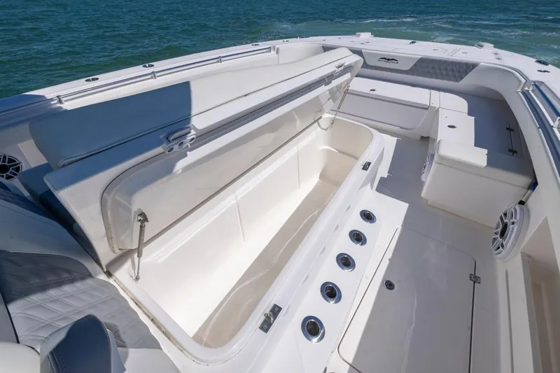  Yacht Photos Pics 2023 Invincible 37 Catamaran interior with open storage compartment, ocean backdrop.