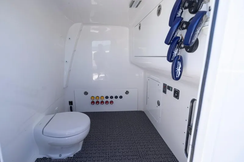  Yacht Photos Pics Interior of 2023 Invincible 37 Catamaran featuring a compact marine toilet and control panel.