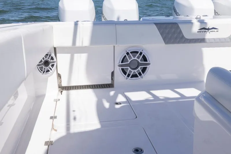  Yacht Photos Pics 2023 Invincible 37 Catamaran interior with speakers, white seating, and ocean backdrop.