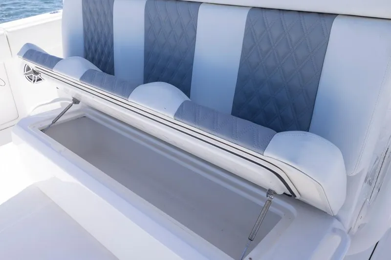  Yacht Photos Pics 2023 Invincible 37 Catamaran seat with storage compartment open, featuring blue and white upholstery.