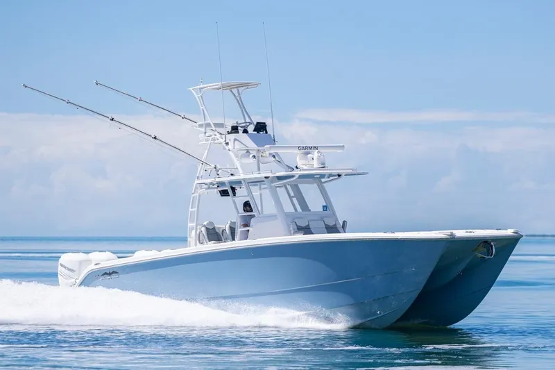  Yacht Photos Pics 2023 Invincible 37 Catamaran cruising on calm ocean waters.