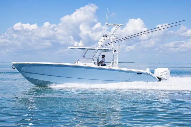  Yacht Photos Pics 2023 Invincible 37 Catamaran cruising on clear blue waters under a bright sky.