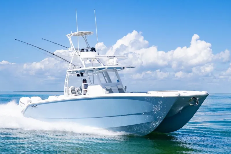 Yacht Photos Pics 2023 Invincible 37 Catamaran cruising on clear blue ocean under a bright sky.