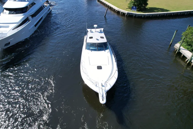  Yacht Photos Pics Aerial view of a 1999 Uniesse 57 Open yacht navigating a narrow waterway.