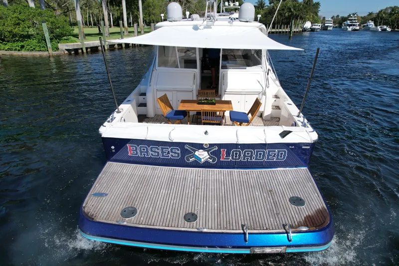  Yacht Photos Pics 1999 Uniesse 57 Open yacht on water, rear view with deck and seating area.