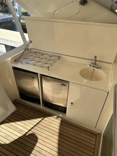  Yacht Photos Pics Compact kitchenette on a 1999 Uniesse 57 Open yacht with stove, sink, and storage.