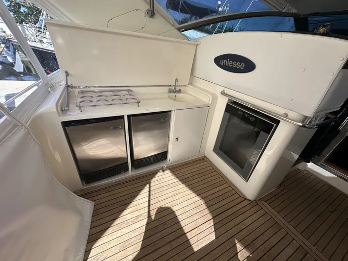  Yacht Photos Pics 1999 Uniesse 57 Open yacht interior with kitchenette and wooden flooring.