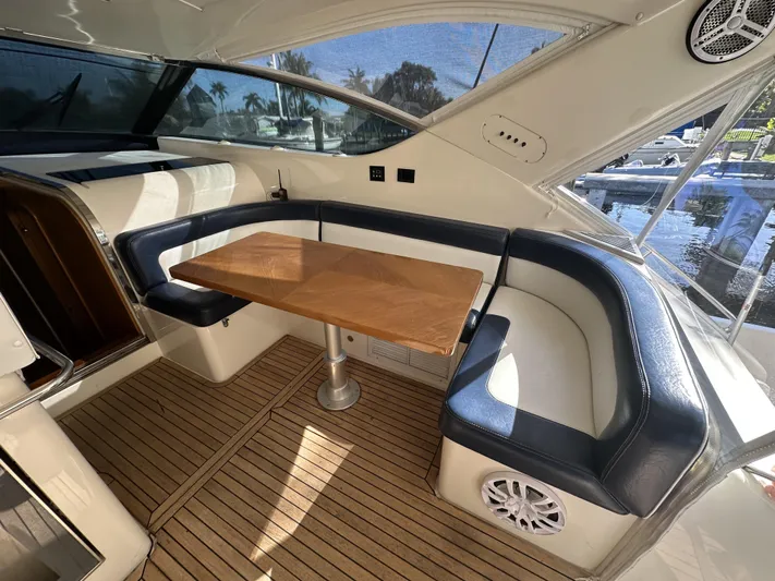  Yacht Photos Pics Luxurious seating area on 1999 Uniesse 57 Open yacht with wooden table and leather upholstery.
