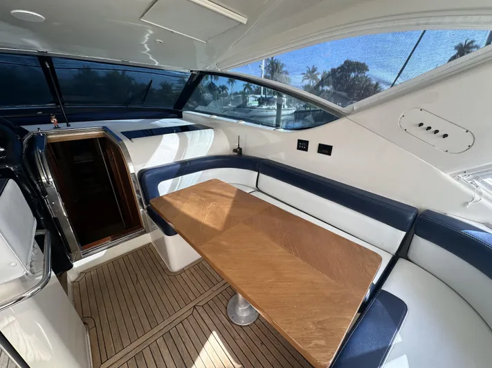  Yacht Photos Pics Interior of 1999 Uniesse 57 Open yacht with wooden table and blue seating.