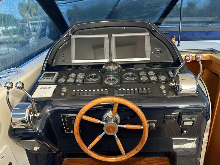  Yacht Photos Pics Control panel of a 1999 Uniesse 57 Open yacht with wooden steering wheel.