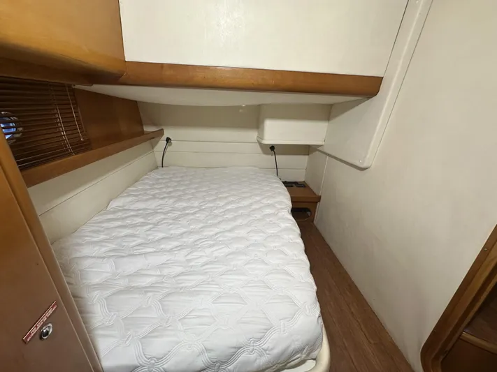  Yacht Photos Pics 1999 Uniesse 57 Open cabin with a cozy bed and wooden accents.