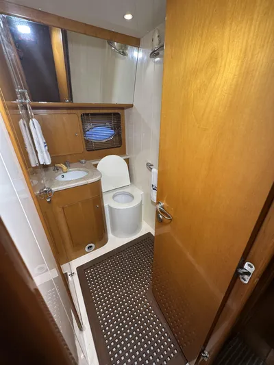  Yacht Photos Pics Bathroom interior of 1999 Uniesse 57 Open yacht, featuring wooden cabinetry and modern fixtures.