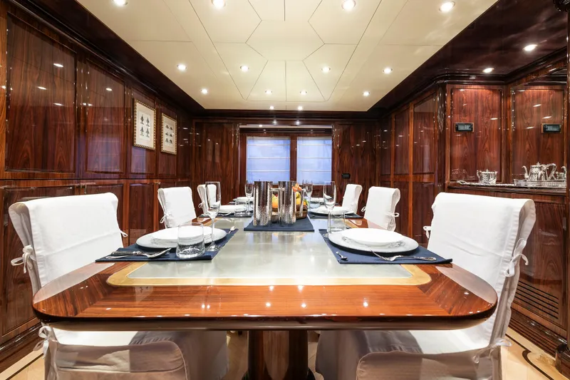 Claudia Berruto Yacht Photos Pics Luxurious dining area on Baglietto M/Y 32 D yacht, featuring elegant wood paneling and table setting.